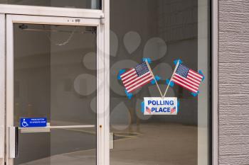 USA flags stuck to window of Polling place for early voting in the USA elections