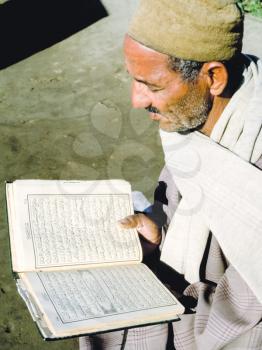 Giza, Egypt - May 23, 2017: An elderly man reads the Koran. Egyptian Muslim
