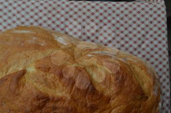 Bread. A loaf of bread. Freshly baked bread. Tablecloth. Delicious. Food. Kitchen. Close-up. Horizontal photo