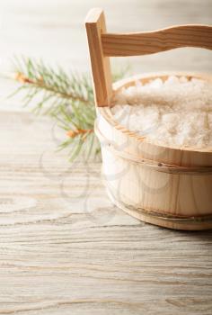 Aromatic bath salt in wooden bucket and pine branch 