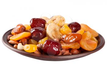 Dried fruits isolated on a white background. Dates, lemon, apricots, figs and nuts in a clay plate.