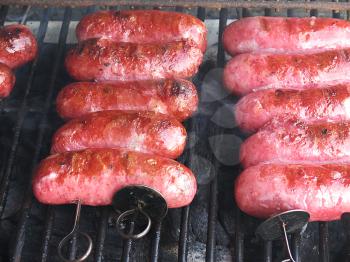 Grilled sausages on grill, with smoke above it