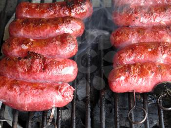 Grilled sausages on grill, with smoke above it