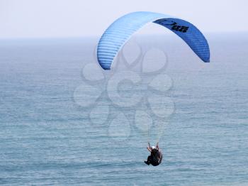 Paraglider is flying in the blue sky