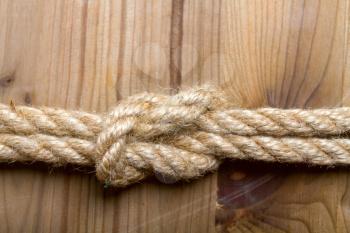 sea knot of rough rope on a simple wooden light brown background