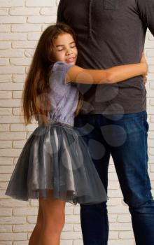 little girl loving hugging her dad's waist