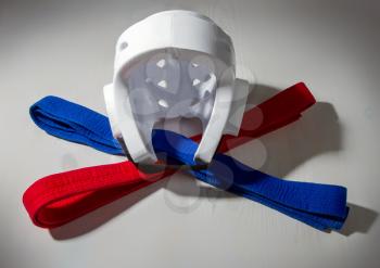 White protective light helmet for karate do, and red and blue belts for competitions