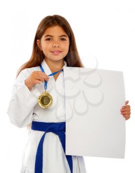 karate girl with a blue belt and a white kimono and a medal for first place holds a blank sheet of paper in her hands with a place for text.