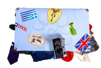 old suitcase full of things to relax with stickers from visited places ready for travel isolated on white background