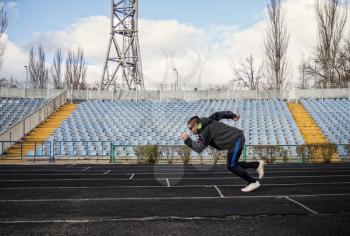 man in sportswear goes in for sports jogging through an empty stadium