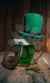 Leprechaun hat stands on a glass mug with green beer in an Irish pub for St. Patrick's Day