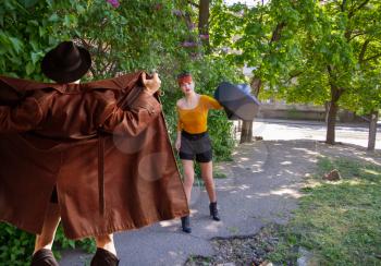 A male exhibitionist opened a leather cloak and suddenly jumped out in front of a young girl on a deserted street, while she defends herself with a bag