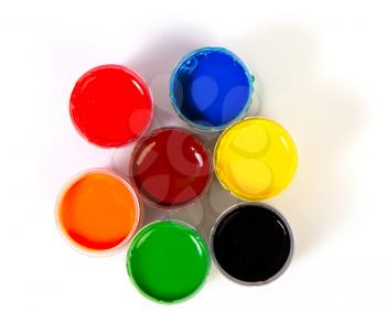 Several open jars of gouache paint of different colors isolated on a white background. View from the top.