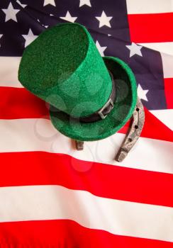 The classic green Leprechaun hat and horseshoe rests on the Stars and Stripes USA banner 