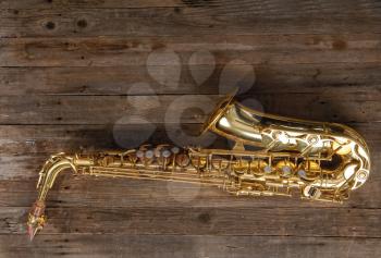 graceful classical musical instrument bronze saxophone on old wooden background