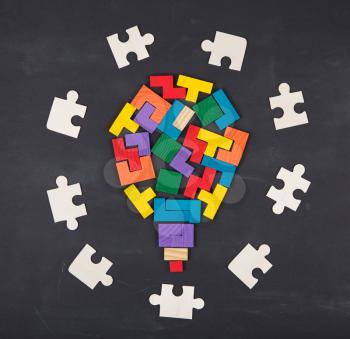 Business creative Idea concept - bulb composed of jigsaw color block on the blackboard