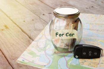 Car finance concept - money glass with word For car, car key and roadmap
