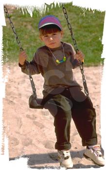 Royalty Free Photo of a Young Boy on a Swing
