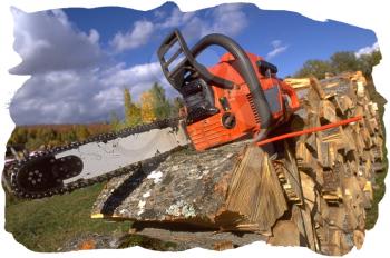 Royalty Free Photo of a Chain Saw Placed on Top of a Pile of Cut Wood