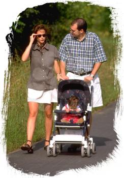 Royalty Free Photo of a Couple Walking Their Baby