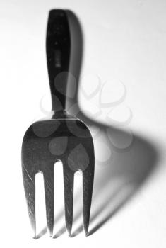 Lowkey shoot of metallic fork, with big shadow.