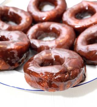 Sweet donuts on the plate with chocolate glaze.