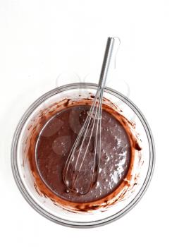 Mixing of a chocolate dough in a glass bowl for making a cake.