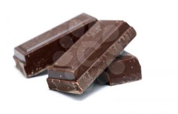 Heap of the pieces of dark chocolate on white background.