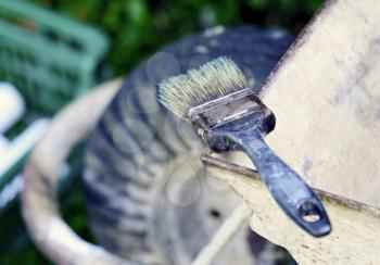 Old used paint brush put on the top of wheelbarrow. Paint brush after painting.