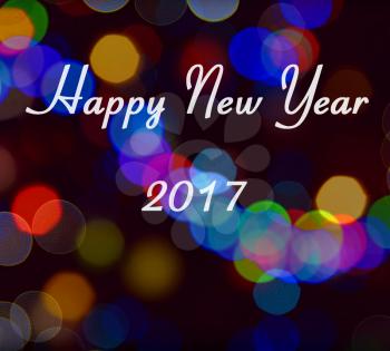 Card with Happy New Year 2017 writing on multicolor light bokeh. New Year 2017 card.