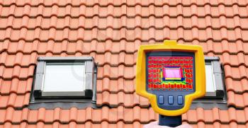 An infrared thermal imager showing roof window heat loss.