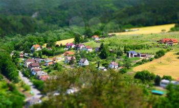 Beautiful village with houses in valley shot with tilt shift effect.