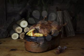 Christmas Duck Roast At The Wooden Table With Wood Logs and Pine Branches In The Background