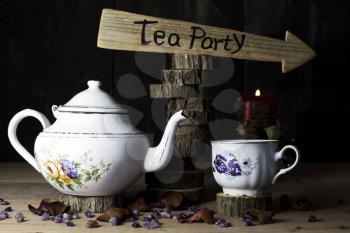 Tea Party. Cup of Tea and Teapot On Wooden Table With Arrow Sign in the Background
