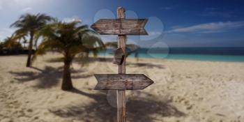 Wooden Arrow Sign at Sandy Beach at Tropical Island. Summer Vacation Concept