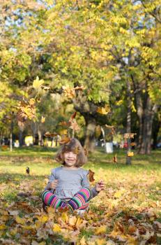 happy little girl fun with autumn leaves