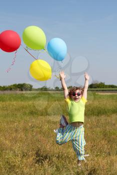 little girl with colorful balloons jumping