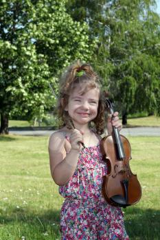 happy little girl with violin in park