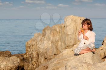 little girl playing pan pipe by the sea
