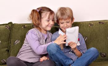 happy little girl and boy playing with tablet pc
