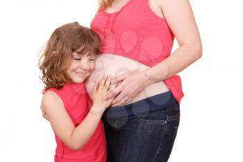 little girl embracing her pregnant mother 