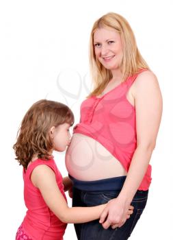 little girl kissing belly of pregnant woman 