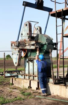oil worker with pipe wrench working