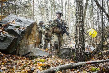 Norwegian Rapid reaction special forces FSK male and female soldiers in field uniforms patrolling in the forest trees