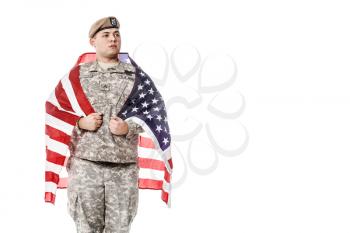 Army Ranger from Special Troops Battalion in universal Camouflage pattern Uniforms and Tan beret with Ranger Regiment crest standing weraing US flag on his shoulders. National holidays: Veterans Day, Memorial Day
