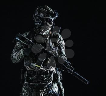 US marine riders shooter, army special forces soldier standing in darkness in mask, battle uniform, quad-tube, four lenses night vision goggles on helmet, low key, side view, studio portrait on black