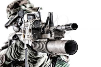 Close up studio shoot of modern commando soldier, US army marine riders shooter looking trough weapon optics, aiming service rifle with laser sight and grenade launcher isolated on white background