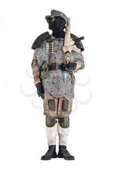 Post apocalyptic soldier in black mask and glasses, wool field cap and handmade armor from car tires and hauberk, standing at attention with submachine gun on shoulder, isolated on white studio shoot