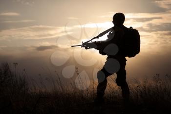 Silhouette of US marine with rifle  against the sunset