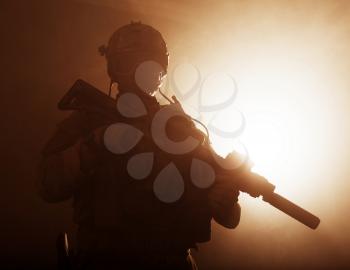 Special forces soldier with rifle in the smoke